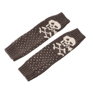 Detail of dark brown knitted leg warmers featuring white skull and crossbones patterns