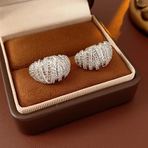 Macro shot of silver paved zircon hoop earrings in a brown velvet jewelry gift box