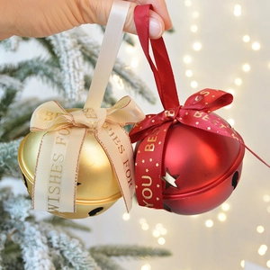 Festive red and gold metal Christmas bells with Best Wishes satin ribbons on tree
