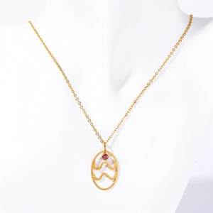 Gold stainless steel zodiac necklace with red gemstone pendant on white mannequin