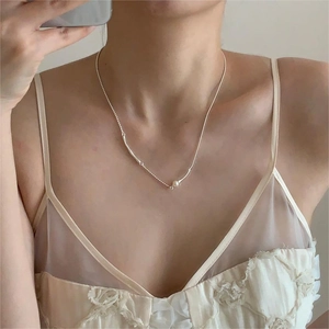 Detail of 925 sterling silver clavicle necklace with smooth pearl and metallic curved tube