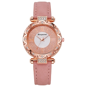 Detail of pink leather watch strap with rose gold rhinestone bezel and white dial face