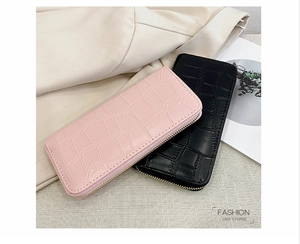 Close-up of embossed crocodile pattern on pink and black long PU leather wallets