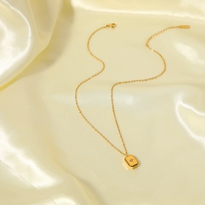 18k gold plated stainless steel necklace with starburst engraved square pendant on silk