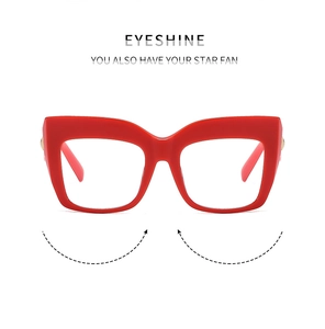 Detail of red cat-eye glasses frame featuring metallic hinge accents and glossy finish