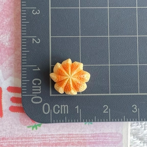 Miniature resin orange slice for DIY crafts shown next to a ruler for 1.8cm scale size
