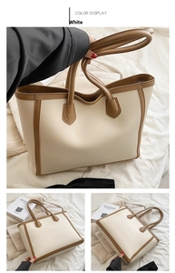 Detail view of cream tote bag with brown trim showing large capacity and trapezoid shape