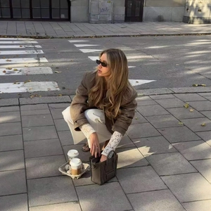 Piccola borsa chic in pelle marrone mostrata in una scena di stile urbano all'aperto