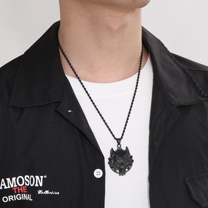 Nahaufnahme einer schwarzen Wolfskopf-Halskette im Punk-Stil mit gedrehter Kordelkette
