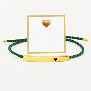 Detailed shot of green woven bracelet with gold 'Just breathe' bar and gift card