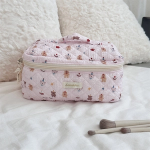 Detailed view of pink quilted cotton makeup bag with bear pattern and handle