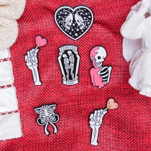 6-piece Gothic enamel pin set featuring skeletons and hearts on red fabric background