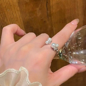 Elegant silver pearl flower open ring with sparkling cubic zirconia on a model's finger