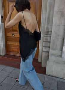 Détail du dos d'un caraco noir en satin avec bordure en dentelle et design dos nu élégant
