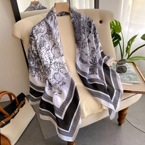 Detail shot of the black and white silk scarf draped over a chair in a stylish home setting