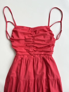 Close-up of ruched bust detail and adjustable spaghetti straps on pink maxi dress