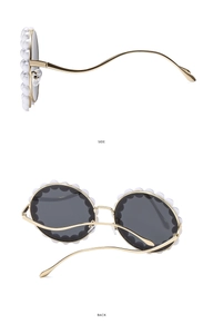 Detail view of round sunglasses with pearl trim and gold wavy temples on white background