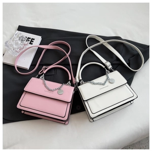 Detailed view of pink and white PU leather crossbody bags with chain and FASHION logo