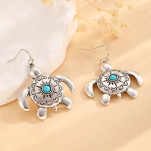 Detail of vintage silver turtle earrings with blue bead and bohemian engravings
