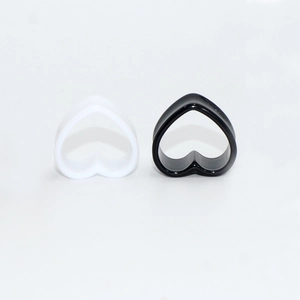 Pair of hollow heart-shaped acrylic ear gauges in black and white glossy finish