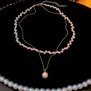 Detail of elegant double-layered vintage pearl necklace on black velvet background
