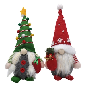 Détail de deux gnomes de Noël en peluche avec bonnets rouge et vert et ornements festifs