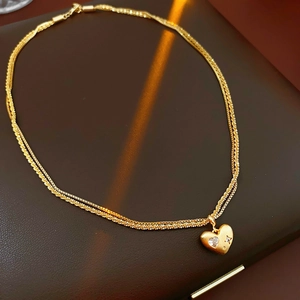 Détail du collier double couche plaqué or avec pendentif coeur serti de pierres