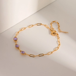 Detail of 18k gold stainless steel bracelet with three inlaid purple zircon stones
