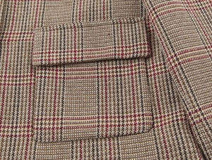 Close-up detail of the brown houndstooth wool blazer showing fabric texture and pocket seams