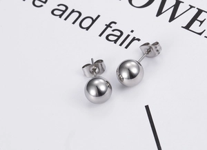 Macro detail of polished stainless steel ball stud earrings with butterfly backings