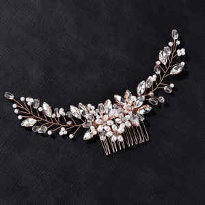 Detail of rose gold bridal hair comb with pearls and marquise crystals on black background