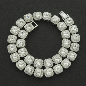 Macro view of silver hip hop necklace featuring square crystals and paved small diamonds