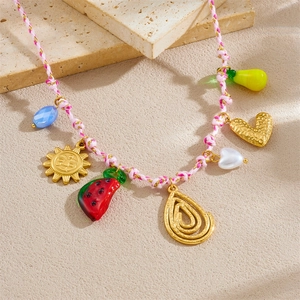 Close-up of colorful braided rope necklace with sun, heart, and fruit charms detail