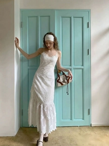 Détails de broderie et ourlet à volants sur cette robe longue blanche en dentelle