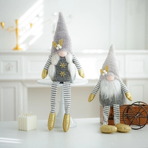 Detail of plush Christmas gnomes in grey and gold tones on a cozy white interior background
