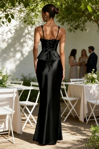 Close-up of elegant black satin corset top with back lace-up detail and peplum waist