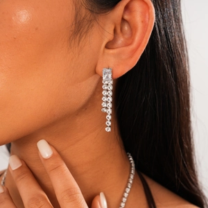 Detailed close-up of zircon square tassel earrings and matching necklace set on model