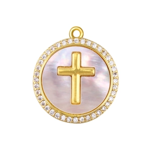 Macro detail of round gold cross pendant with pink mother of pearl and zircon border