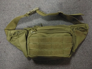 Detail of army green tactical waist bag showing multiple zipper pockets and nylon fabric