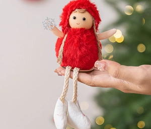 Close-up of red plush Christmas doll with silver snowflake and rustic jute rope limbs