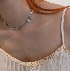 Close-up of three silver butterfly charms on a sleek flat snake chain necklace