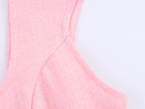 Macro shot of pink tweed fabric texture and precise stitching on French style dress