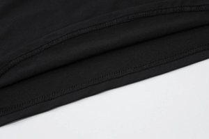 Gros plan détaillé de l'ourlet à double couture et de la maille sur robe noire