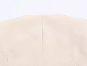 Makro-Detail der zentralen Rückennaht eines beigen Blazers aus feinem glattem Stoffgewebe