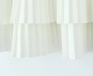 Detailed macro view of white layered pleated hem on a sweet style mini skirt