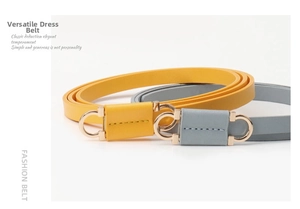 Close-up of yellow and grey leather belts for dresses with golden horseshoe buckles
