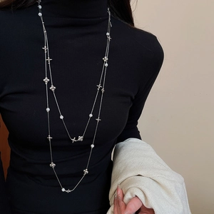 Close-up of double-layer silver star and flower necklace with sparkling rhinestones