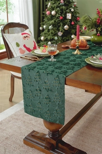 Detail of green Christmas table runner with 3D tree embroidery on a wooden table