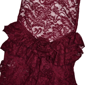 Macro shot of dark red floral lace texture with ruffle straps and fabric flower detail