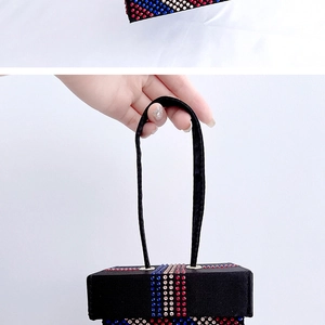 Detail of black rhinestone evening bag with red white and blue crystal stripes